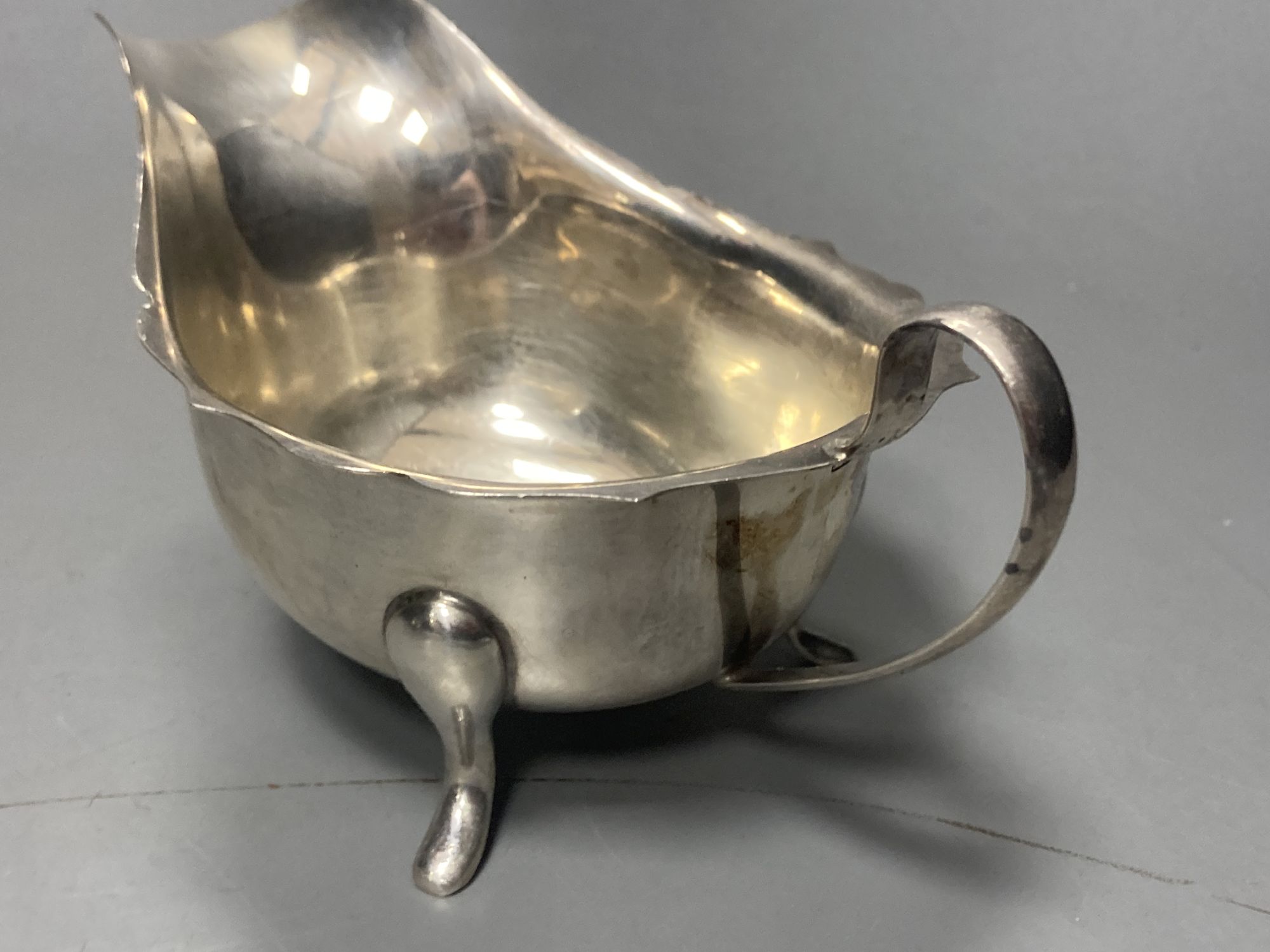 A late 19509s silver sauceboat on stand, Viners Ltd, Sheffield, 1958/9 and a George V silver porringer,